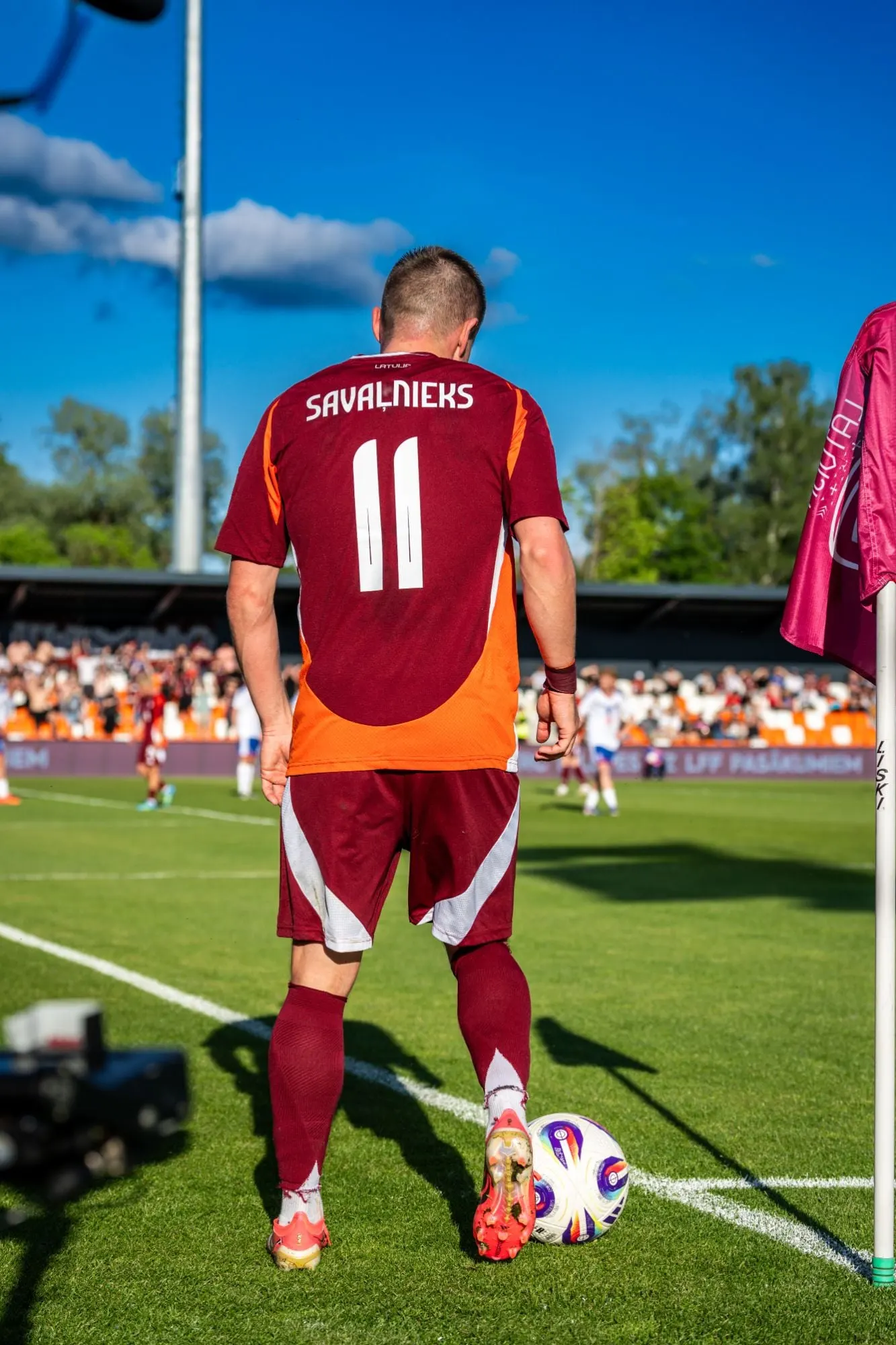 A player wearing number 11 preparing to take a corner kick