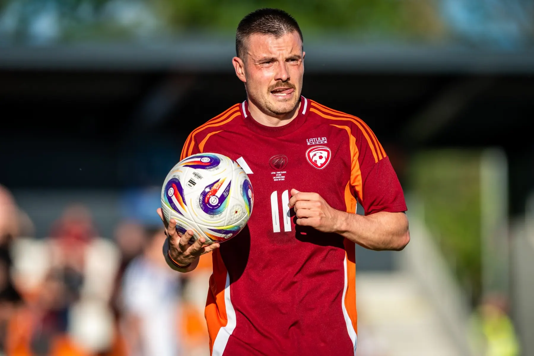 A Latvian national team player holding the ball